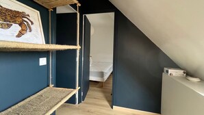 A room with a sloped ceiling, a framed artwork on the wall, and a wooden floor. - Charming house near beach in Groix, 2 bedrooms (Groix)