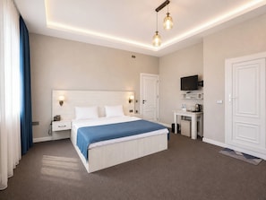 A hotel room with a bed, bedside tables, a desk with a chair, a television, and a wardrobe. - Central Baku Hotel (Baku)