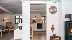 A modern kitchen with white cabinets, a black oven, and a copper pot on the stove.