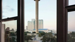 Una habitación con un amplio ventanal que da a una torre y edificios altos.