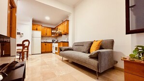 A compact living space with a sofa, a dining table, and a kitchen area. - Click&Guest - 1Naval Nautical Ap. in Gran Canaria (Las Palmas de Gran Canaria)