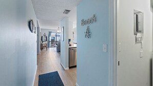 Un pasillo con pared azul, una decoración de estrella de mar y una puerta con picaporte.