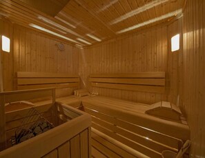 Una sauna con bancos de madera y un banco con perchero.