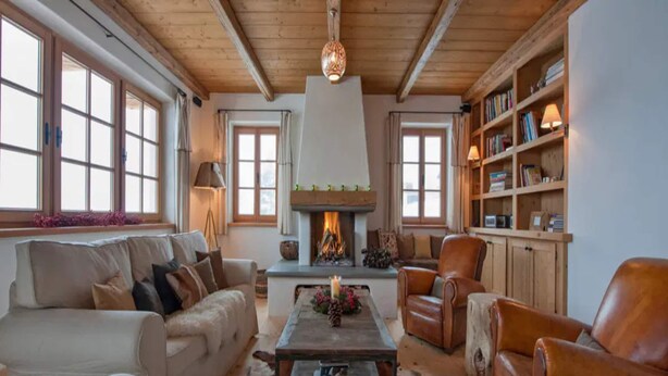 A cozy living room with a fireplace, leather armchairs, a sofa, and a bookshelf. - Chalet Baker Vacation Home (Pettneu am Arlberg)