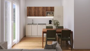 A modern kitchen with wooden cabinets, a dining table with chairs, and a view of greenery outside. - Apartment Villa in Limone Sul Garda (Limone sul Garda)