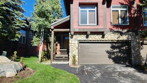 A two-story house with a stone facade, a garage, and a well-maintained lawn. - Snowcreek Resort Vacation Rental 733 (Mammoth Lakes)