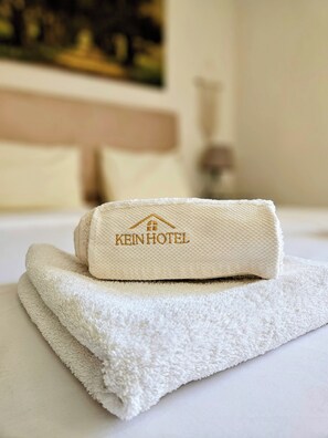 A neatly folded towel with a hotel logo on a bed. - Central Apt with a Panoramic view over Cairo & Nile (Giza Governorate)