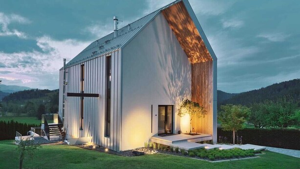 Un bâtiment moderne, de plain-pied, doté d’un toit en pente, de grandes fenêtres et d’un petit espace porche.