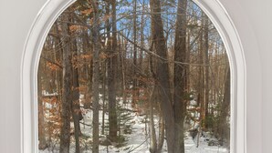 A room with a large arched window overlooking a snowy forest. - 3 bedroom Chic condo - Community pool and tennis - 1 Mile to Mount Snow (Dover)