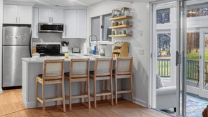 A modern kitchen with white cabinets, stainless steel appliances, and a wooden ceiling. - 3 bedroom Chic condo - Community pool and tennis - 1 Mile to Mount Snow (Dover)
