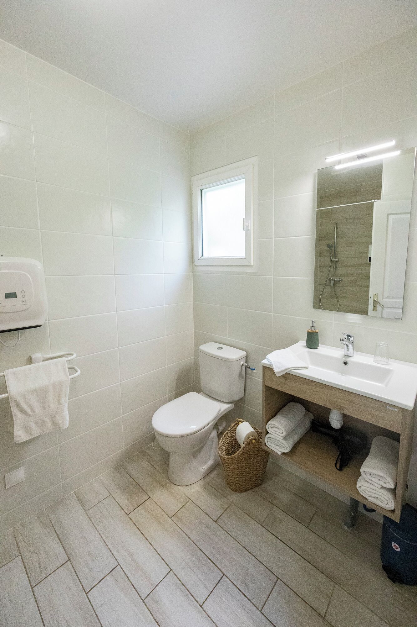Un baño con inodoro, lavamanos y ventana.