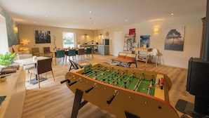 Un'ampia zona giorno con tavola da calcio, angolo ristoro e cucina.
