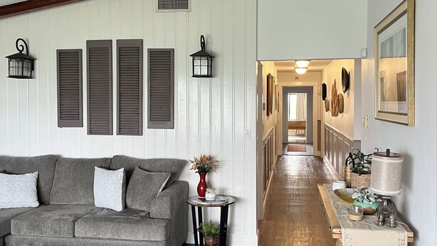 A cozy living room with a grey sofa, a patterned rug, and a wooden floor. - Lake Jackson beachfront home w/dock, pool table, close to restaurants/shops (Sebring)