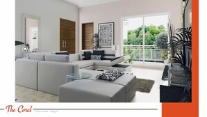 Un salon moderne avec un canapé d’angle, une table basse et une grande fenêtre donnant sur un paysage verdoyant.