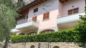 A two-story building with balconies, stone walls, and a sign reading "Villa Giama".