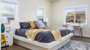 Une chambre moderne avec un grand lit, des tables de chevet, un bureau et une chaise.
