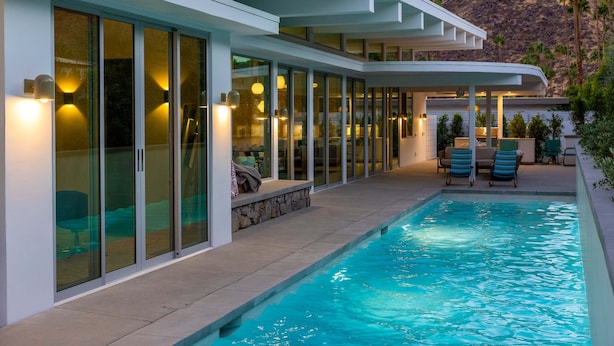 A modern house with a swimming pool, large glass doors, and a patio area. - Webb House – Mid-Century Modern in Vista Las Palma (Palm Springs)