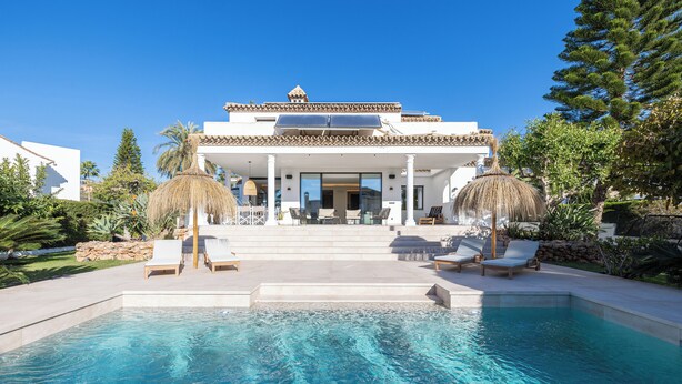 A modern villa with a swimming pool, outdoor seating, and a covered patio. - Villa El Paraiso Marbella- 4 Bedrooms (5-Beds) (Benahavís)