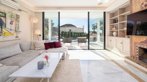 A spacious living room with a sofa, coffee table, and a fireplace. - Villa El Paraiso Marbella- 4 Bedrooms (5-Beds) (Benahavís)