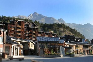 Un edifici de fusta tradicional amb diversos balcons, amb les muntanyes al fons.