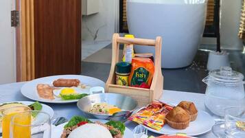 Un desayuno con diversas opciones de comida, una bañera y una planta en maceta.