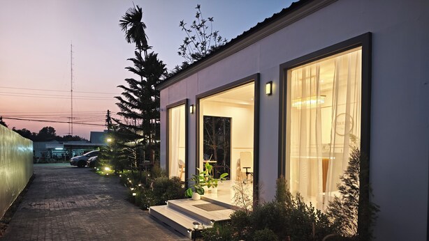 A modern house with large windows, a paved driveway, and outdoor lighting. - S'Villa  (Warin Chamrap)