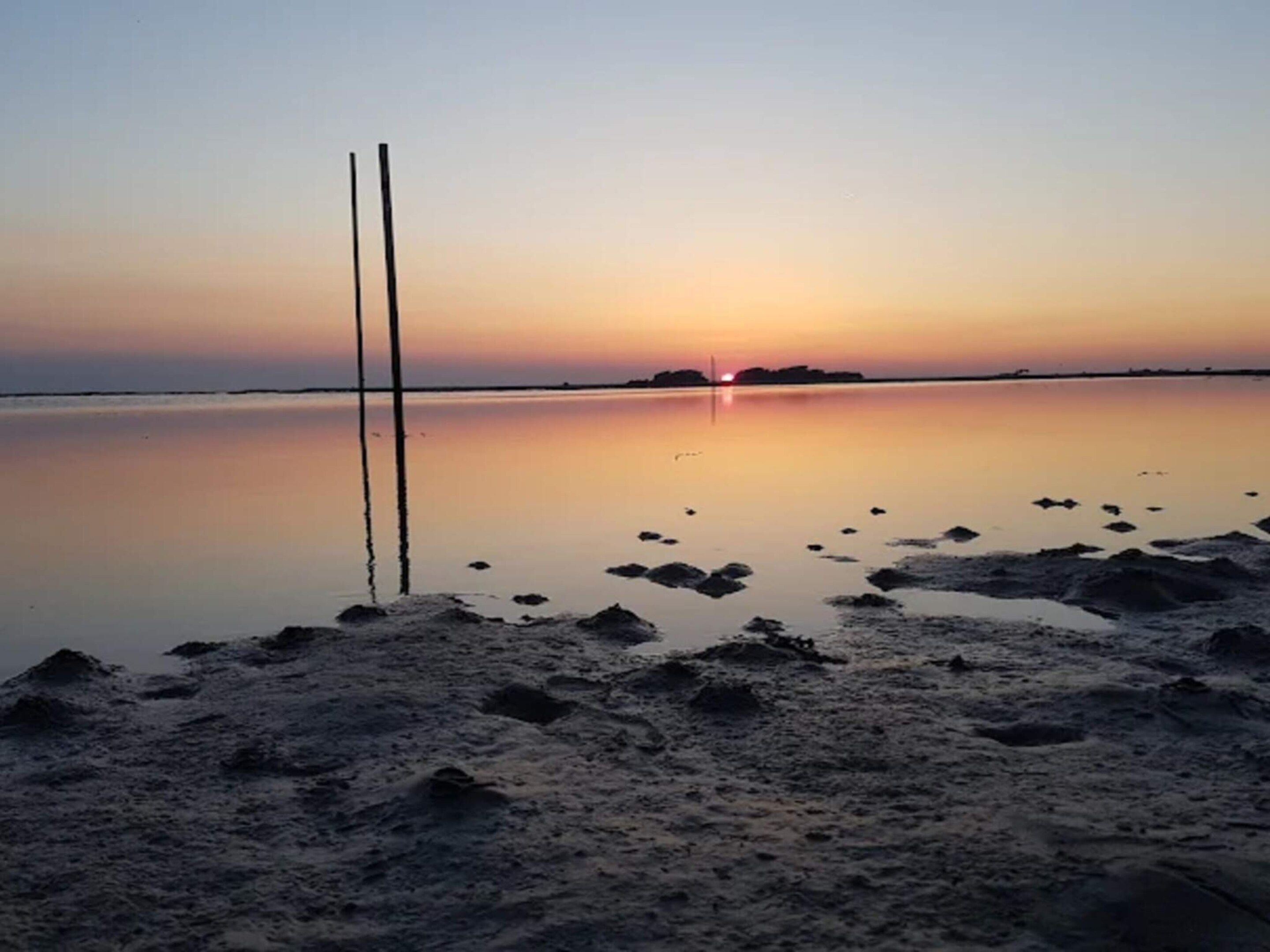 A calm lake at sunset with a clear sky.