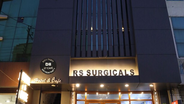 A building with a sign for 'Hotel & Cafe' and 'RS Surgeicals'. - Hotel Dhruv Inn (Bareilly)