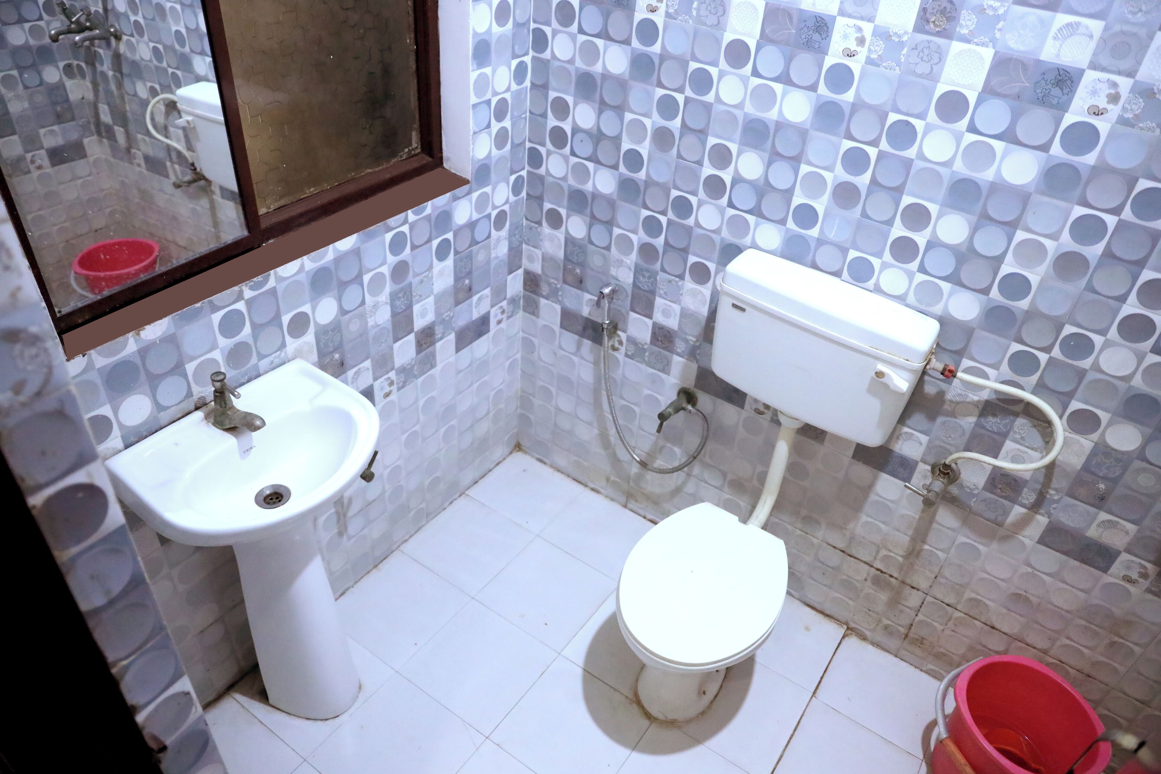 A small bathroom with a white sink, toilet, and a mirror.