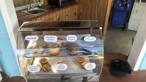 A bakery display case with various muffins and frittatas labeled with flavors like blueberry, cranberry orange, banana walnut, chocolate, egg cheese vegetable fritta, egg sausage fritta, and egg cheese fritta. - Seafarer Key Largo (Key Largo)