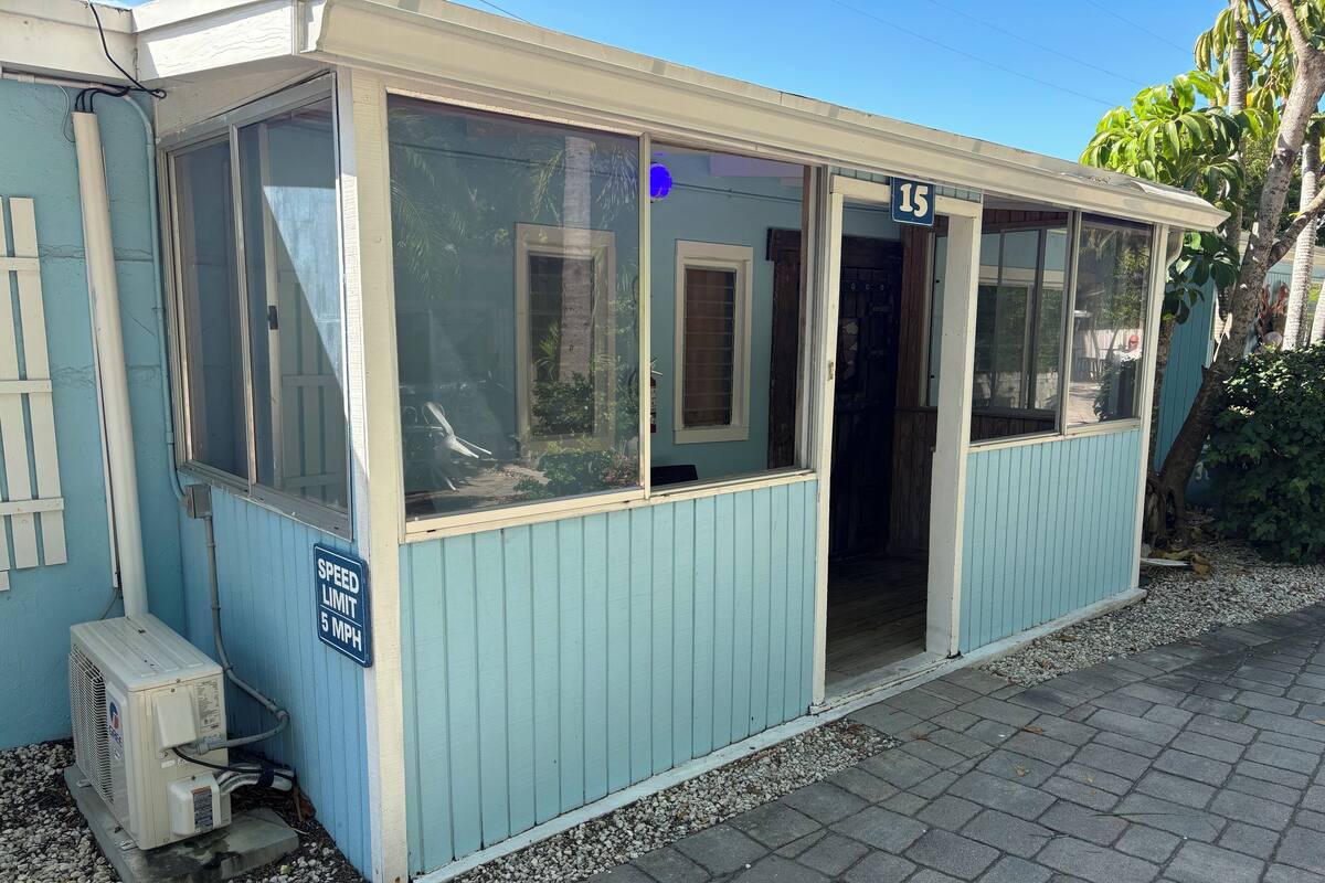 A small, light blue building with a sign indicating a speed limit of 5 MPH.