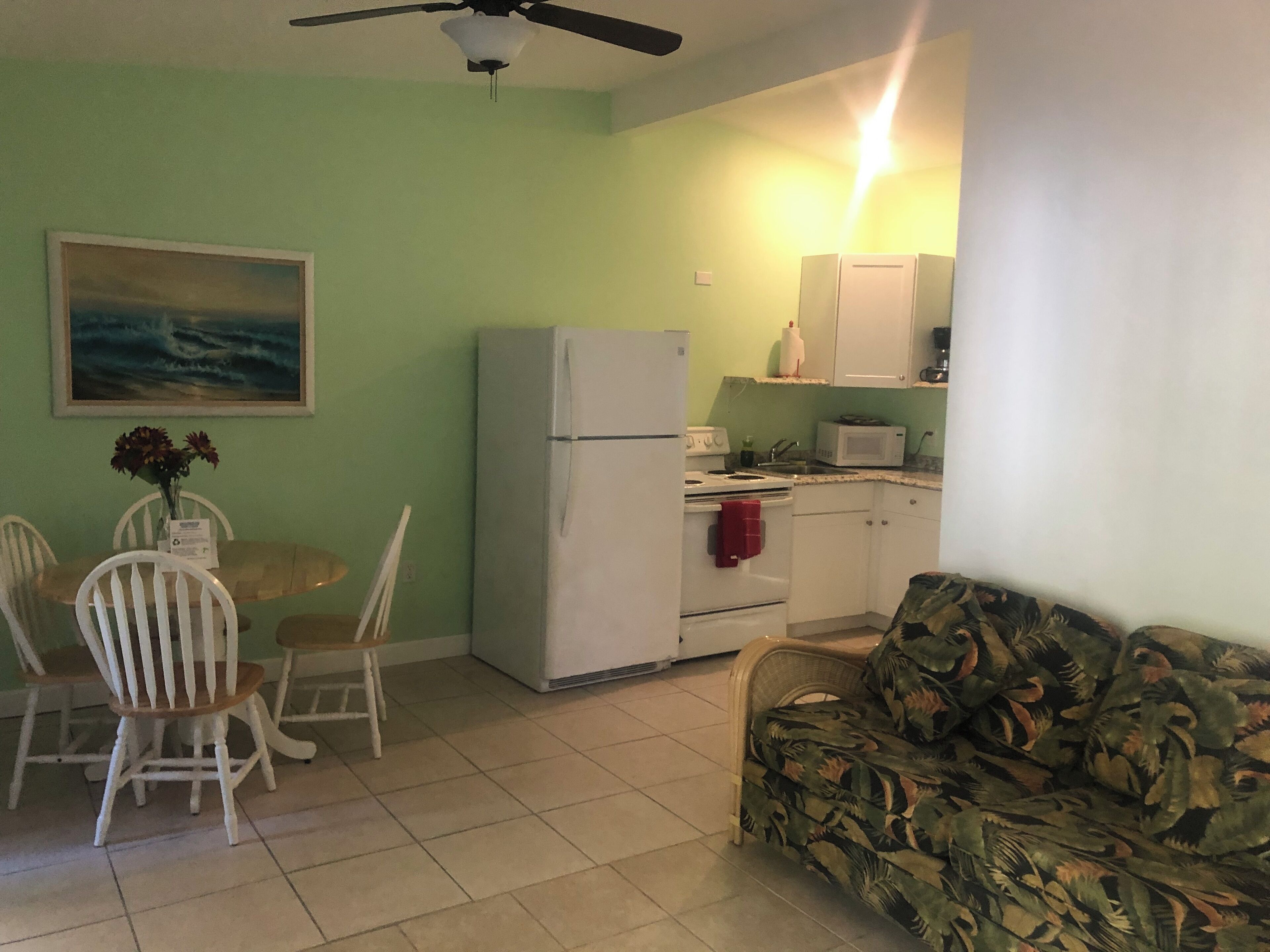 A compact living space with a dining area, kitchenette, and a sofa.