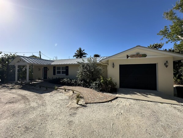 A two-story house with a garage, a covered porch, and a landscaped driveway.