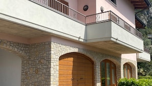 A two-story building with stone walls, wooden doors, and a balcony with metal railings. - Apartment Villa - a Formely TUI Ferienhaus (Limone sul Garda)