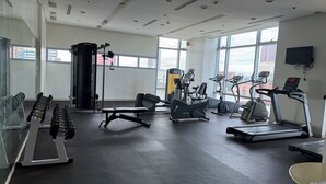 Ein Fitnessraum mit Laufbändern, Crosstrainern und Kurzhanteln.