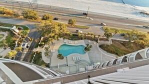 Vista aérea de un complejo turístico con piscina, caminos y vegetación circundante.