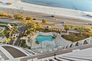 Vista aérea de un complejo turístico con piscina, caminos y vegetación circundante.