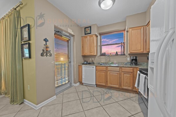 A kitchen with wooden cabinets, a dishwasher, and a refrigerator.