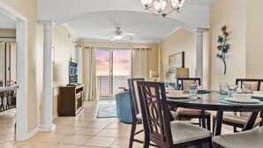 A dining area with a round table, chairs, and a view of the outside. - Legacy Tower II 907 | Deluxe Unit with Stunning Coastal Views! (Gulfport)