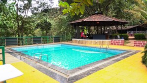 Une piscine dotée d’un kiosque et d’un espace salon abrité.
