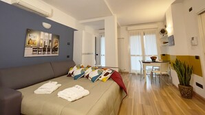 Una habitación de hotel con cama, sofá, zona de comedor y cocina.