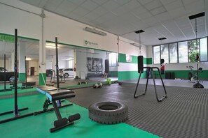 A gym with exercise equipment, a punching bag, and a tire on the floor. - Studio Near Politecnico, Milan (Milan)