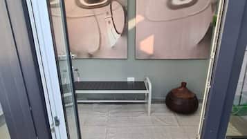 Een modern interieur met een bankje, een deurmat en twee wandlampen.