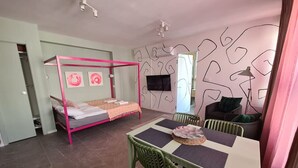 Ein Schlafzimmer mit Etagenbett, Esstisch und Stühlen sowie einem Fernseher an der Wand.