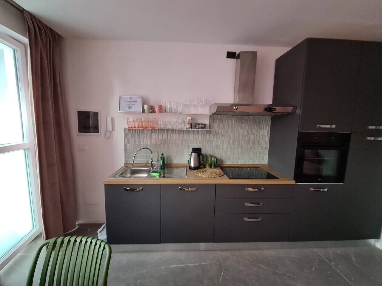 Une cuisine de taille réduite, équipée d’un évier, d’une cuisinière et d’un petit plan de travail.