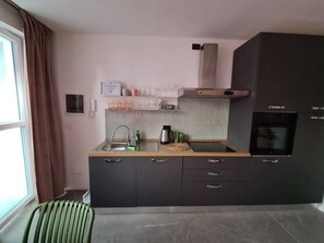A compact kitchen with a sink, stove, and a small countertop.