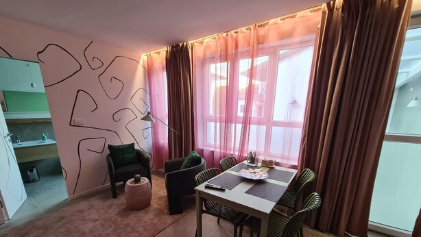 Ein Essbereich mit Tisch und Stühlen, einer Couch und einem kleinen Beistelltisch.