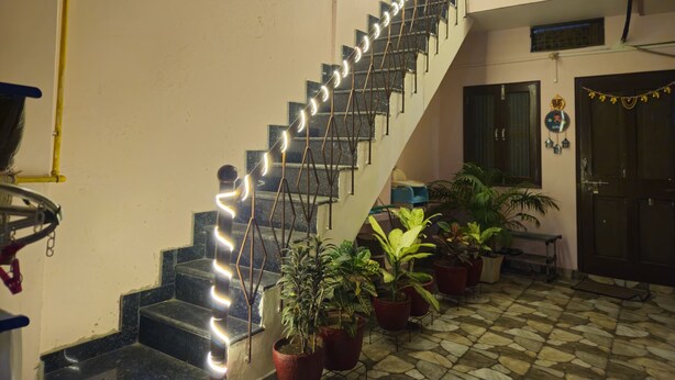 Un escalier agrémenté de luminaires décoratifs, de plantes en pot et d’un sol carrelé.