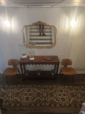 Traditional room with a console table, two chairs, and a large mirror.