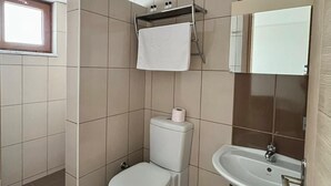 A bathroom with a toilet, sink, and a towel rack.